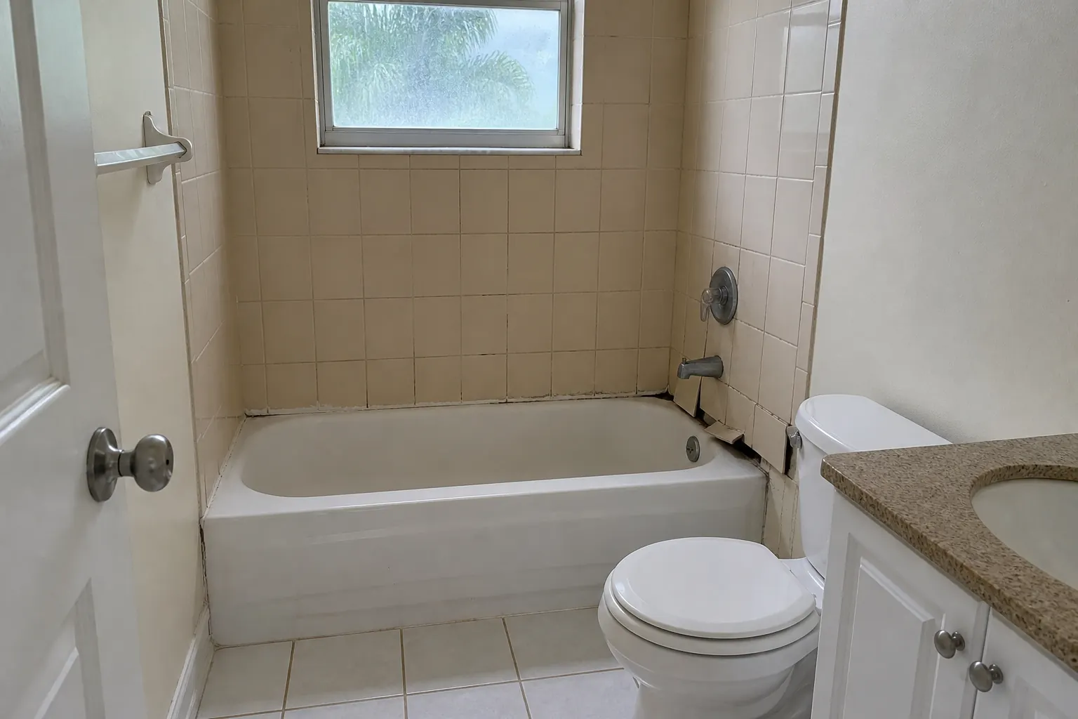 Cracked shower tile and failing grout before bathroom remodeling in Lakeland FL