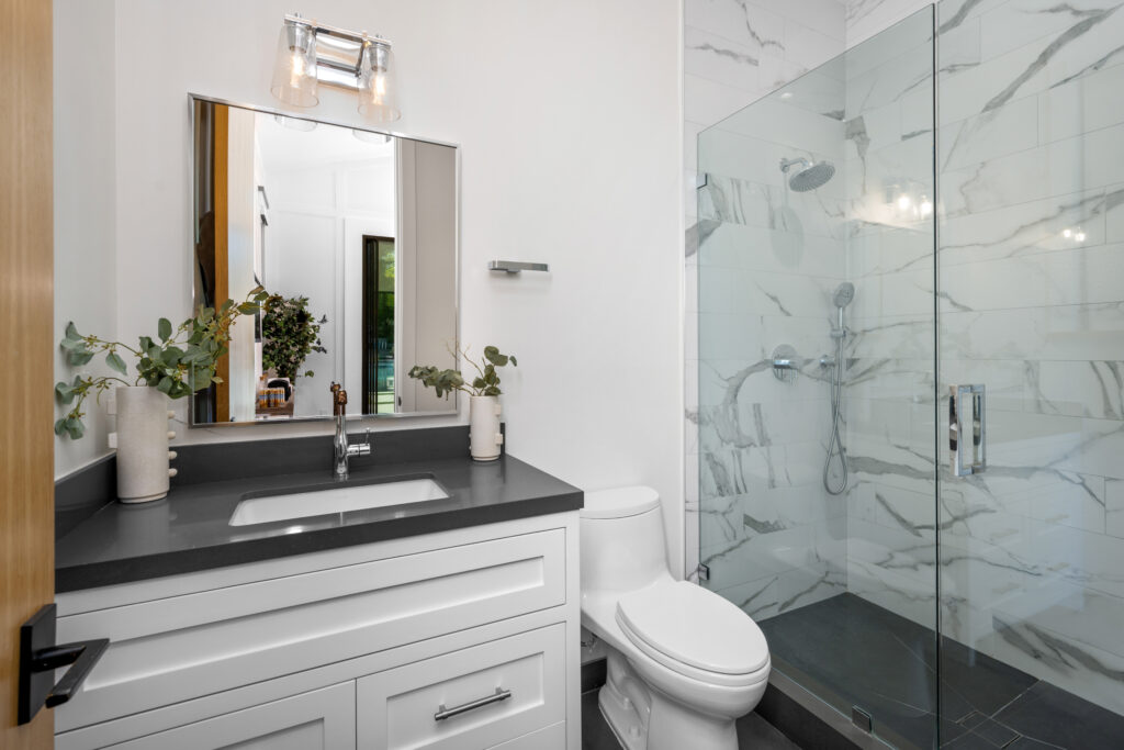 Modern bathroom with white toilet, walk-in glass shower, and contemporary vanity in Central Florida home.