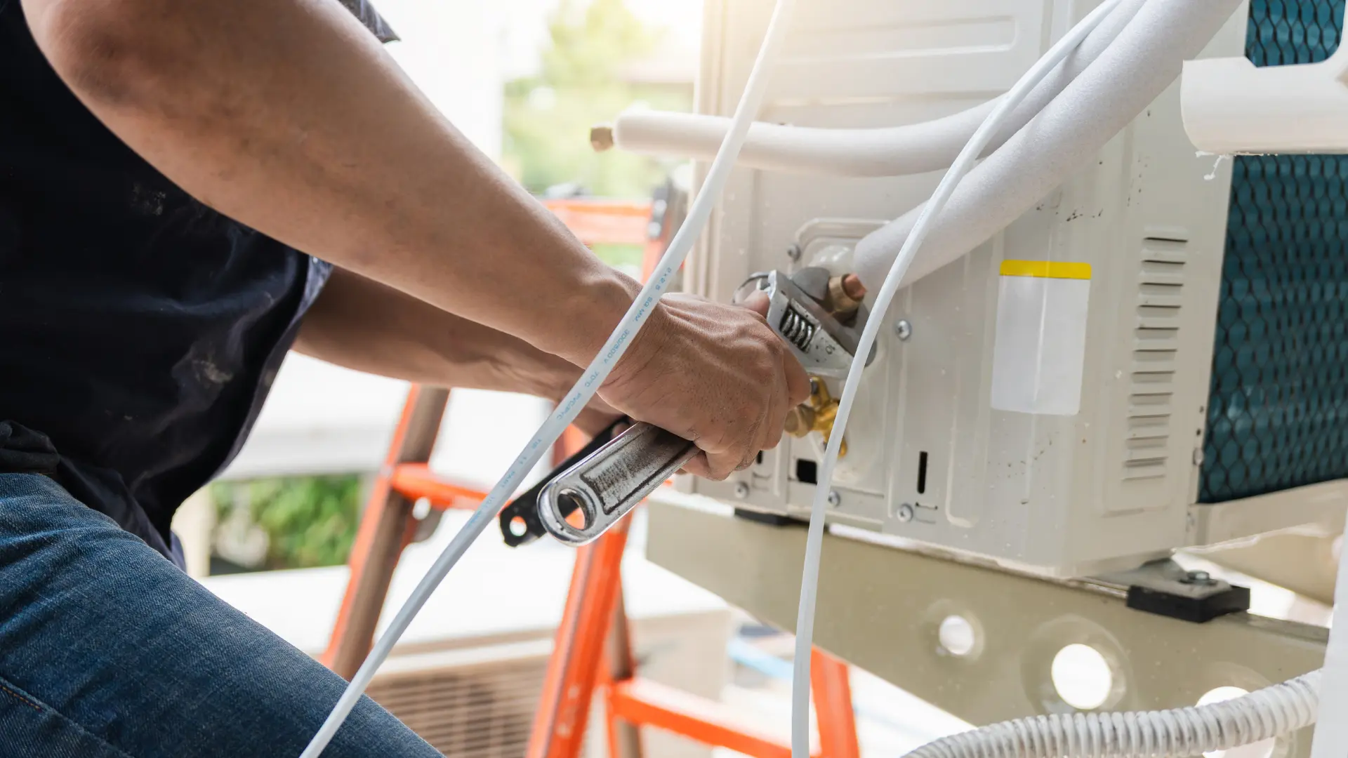 True Builders technician repairing water leak in aircon unit with tools in Central Florida home