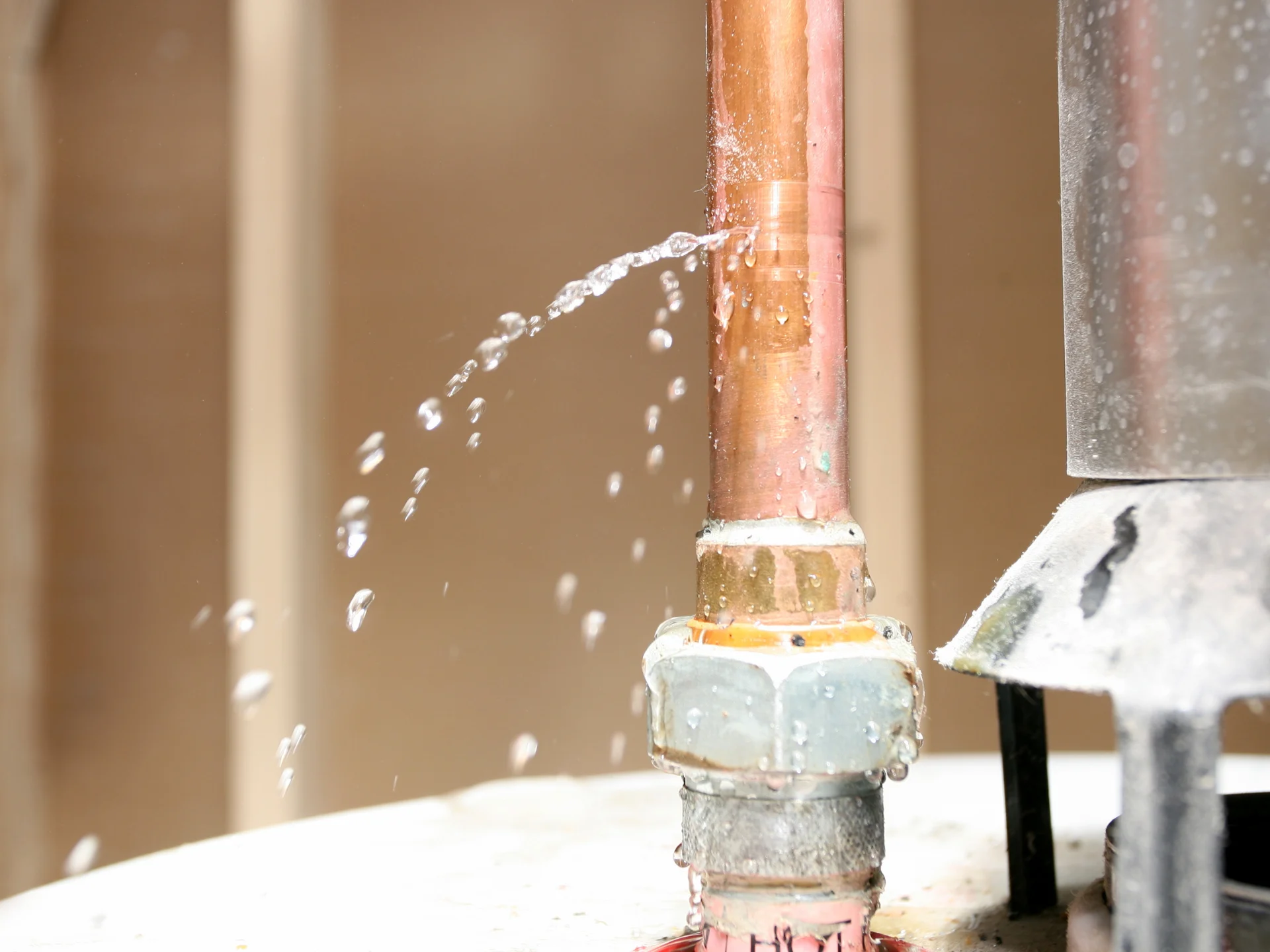 What to do after a water leak in Florida, water spraying from a copper pipe connection